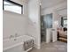 Bright bathroom featuring a glass-enclosed shower and soaking tub next to Primary bedroom at 14105 Ryker Way, Davidson, NC 28036