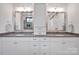 Bathroom featuring a double vanity with gray countertop, framed mirrors, and cabinet storage at 14105 Ryker Way, Davidson, NC 28036