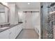 Bathroom featuring double sinks, storage, sliding barn door, and a walk in shower at 14105 Ryker Way, Davidson, NC 28036