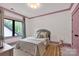 Cozy bedroom with soft pink trim, a comfortable bed, and a window that brings in ample natural light at 14105 Ryker Way, Davidson, NC 28036