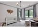 Charming Bedroom with a white crib, soft gray accents, and large windows offering a view of the lush greenery at 14105 Ryker Way, Davidson, NC 28036
