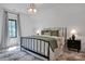 A light-filled bedroom features a black iron bed frame, geometric light fixture, patterned rug and neutral color palette at 14105 Ryker Way, Davidson, NC 28036