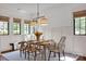 Sunlit dining room with neutral walls, bright windows, and rustic wood table at 14105 Ryker Way, Davidson, NC 28036