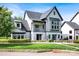 Charming home with a well-manicured front lawn, stone accents, and a mix of board and batten and stucco exterior at 14105 Ryker Way, Davidson, NC 28036