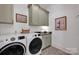 Convenient laundry room with sage cabinetry, granite countertop, and modern washer/dryer at 14105 Ryker Way, Davidson, NC 28036