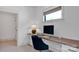 Bright and airy office space featuring a sleek built-in desk, neutral walls, and a comfortable blue swivel chair at 14105 Ryker Way, Davidson, NC 28036