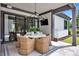 Entertain on this covered patio with an elegant chandelier, TV, and outdoor dining area at 14105 Ryker Way, Davidson, NC 28036