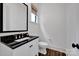 Cozy powder room with black granite countertop, white vanity, and modern fixtures at 14105 Ryker Way, Davidson, NC 28036