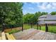 Black metal railings surround a back deck with a partial view of the wooded back yard at 14616 Pomerol Ln, Pineville, NC 28134