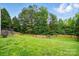 A partial view of a large green backyard surrounded by a wooden privacy fence and a wooded area at 14616 Pomerol Ln, Pineville, NC 28134