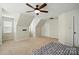 A spacious bedroom featuring neutral carpeting, ceiling fan, and angled ceilings at 14616 Pomerol Ln, Pineville, NC 28134