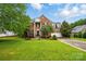 Charming two-story brick home with a lush green lawn, mature trees, and a well-maintained landscape at 14616 Pomerol Ln, Pineville, NC 28134