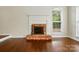 Cozy fireplace with a brick hearth and white mantle in a well-lit living room with hardwood floors at 14616 Pomerol Ln, Pineville, NC 28134