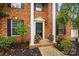 Classic brick home entrance featuring a black front door, white columns, and well-kept landscaping at 14616 Pomerol Ln, Pineville, NC 28134