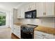 Bright kitchen with white cabinets, granite countertops, tile backsplash, and stainless steel oven and microwave at 14616 Pomerol Ln, Pineville, NC 28134