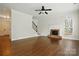Spacious living room featuring hardwood floors, a brick fireplace, and staircase at 14616 Pomerol Ln, Pineville, NC 28134