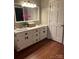 Bathroom with a double sink vanity, white cabinets, and a neutral color scheme with wood-look floors at 1619 Bellamy Cir, Albemarle, NC 28001