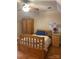 A bedroom boasting natural wood furniture, including a bed and wardrobe, plus warm lighting from a ceiling fan at 1619 Bellamy Cir, Albemarle, NC 28001