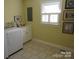 Bright laundry room features a modern washer and dryer set, with tiled floors and a window at 1619 Bellamy Cir, Albemarle, NC 28001