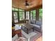 Relaxing sunroom featuring a ceiling fan, neutral-colored furnishings, and wooded outdoor views at 1619 Bellamy Cir, Albemarle, NC 28001