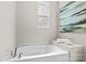 Relaxing bathtub with a window for natural light and a decorative accent at 18339 The Commons Blvd, Cornelius, NC 28031