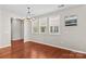 Elegant living room with gleaming hardwood floors, bright windows with shutters, and a modern chandelier for a sophisticated ambiance at 18339 The Commons Blvd, Cornelius, NC 28031