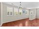 Bright living room with hardwood floors, a modern chandelier, and natural light streaming through the shuttered windows at 18339 The Commons Blvd, Cornelius, NC 28031