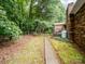 This grassy backyard with an entrance and a propane tank is surrounded by trees at 1878 Pl Propst Rd, Maiden, NC 28650