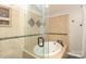 Tile surround and walk-in shower with glass enclosure, in this brightly lit bathroom at 2018 Rosewater Ln, Indian Trail, NC 28079