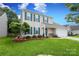 Attractive two-story home featuring green shutters, a landscaped front yard, and a two-car garage at 2018 Rosewater Ln, Indian Trail, NC 28079