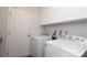 Functional laundry room with white appliances, storage cabinets, and easy access at 2018 Rosewater Ln, Indian Trail, NC 28079