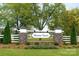 Stone and brick community entrance sign featuring lush landscaping and a white picket fence at 2024 Bramble Hedge Rd # 3275, Indian Trail, NC 28079