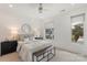 Well-lit bedroom with a window view, ceiling fan, carpet, and a stylish bench at the foot of the bed at 2653 Shenandoah Ave, Charlotte, NC 28205