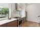 Stainless steel appliances, modern range hood and marbled back splash in kitchen, plus natural light at 2653 Shenandoah Ave, Charlotte, NC 28205