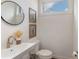 Modern powder room featuring a stylish sink, round mirror, and neutral decor at 2653 Shenandoah Ave, Charlotte, NC 28205