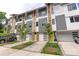Exterior view of modern townhomes showcasing gray siding, colorful doors, and well-maintained landscaping at 2653 Shenandoah Ave, Charlotte, NC 28205