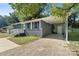 View of a single-story home featuring a brick exterior, carport and gravel driveway at 2701 Ravencroft Dr, Charlotte, NC 28208