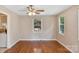 Well-lit living room boasting hardwood floors, a ceiling fan, and large windows for ample natural light at 2701 Ravencroft Dr, Charlotte, NC 28208