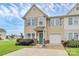 Charming tan townhouse with a teal front door and a well-manicured lawn and one-car garage at 2840 Hopeton Ct, Monroe, NC 28110