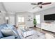 Inviting living room featuring gray walls, wood floors, blue sofa, and entertainment center at 2840 Hopeton Ct, Monroe, NC 28110