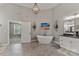 Light-filled bathroom with a standalone tub, vanity with black marble countertop and tiled floors at 3011 Waxhaw Crossing Dr, Waxhaw, NC 28173
