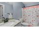Cozy bathroom with a light-colored vanity with marble countertop, and a decorative floral shower curtain at 3011 Waxhaw Crossing Dr, Waxhaw, NC 28173
