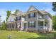 Two-story home with a well-manicured lawn and brick and gray siding, enhanced by a front porch at 3011 Waxhaw Crossing Dr, Waxhaw, NC 28173