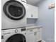Convenient laundry room features stacked washer and dryer, plus storage cabinet and countertop for folding at 3011 Waxhaw Crossing Dr, Waxhaw, NC 28173