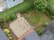 Aerial shot of a backyard with gravel area, a stepping stone path, and shrubs, all surrounded by grass at 308 W Monroe St, Salisbury, NC 28144