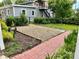 Landscaped backyard with gravel and mulch, surrounded by grass, shrubs, and a brick walkway at 308 W Monroe St, Salisbury, NC 28144