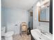 Small, simple bathroom with sky-blue walls, vanity sink, and a toilet with a nearby folding chair at 308 W Monroe St, Salisbury, NC 28144
