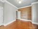 Spacious bedroom featuring hardwood floors, white trim, a wood accent wall, and access to an adjacent room at 308 W Monroe St, Salisbury, NC 28144