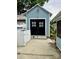 Exterior view of the detached garage with wide, black doors, concrete pad, and weather vane on the roof at 308 W Monroe St, Salisbury, NC 28144