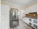 Well lit kitchen boasts stainless steel refrigerator, white cabinets, and decorative wall art on the lower cabinets at 308 W Monroe St, Salisbury, NC 28144